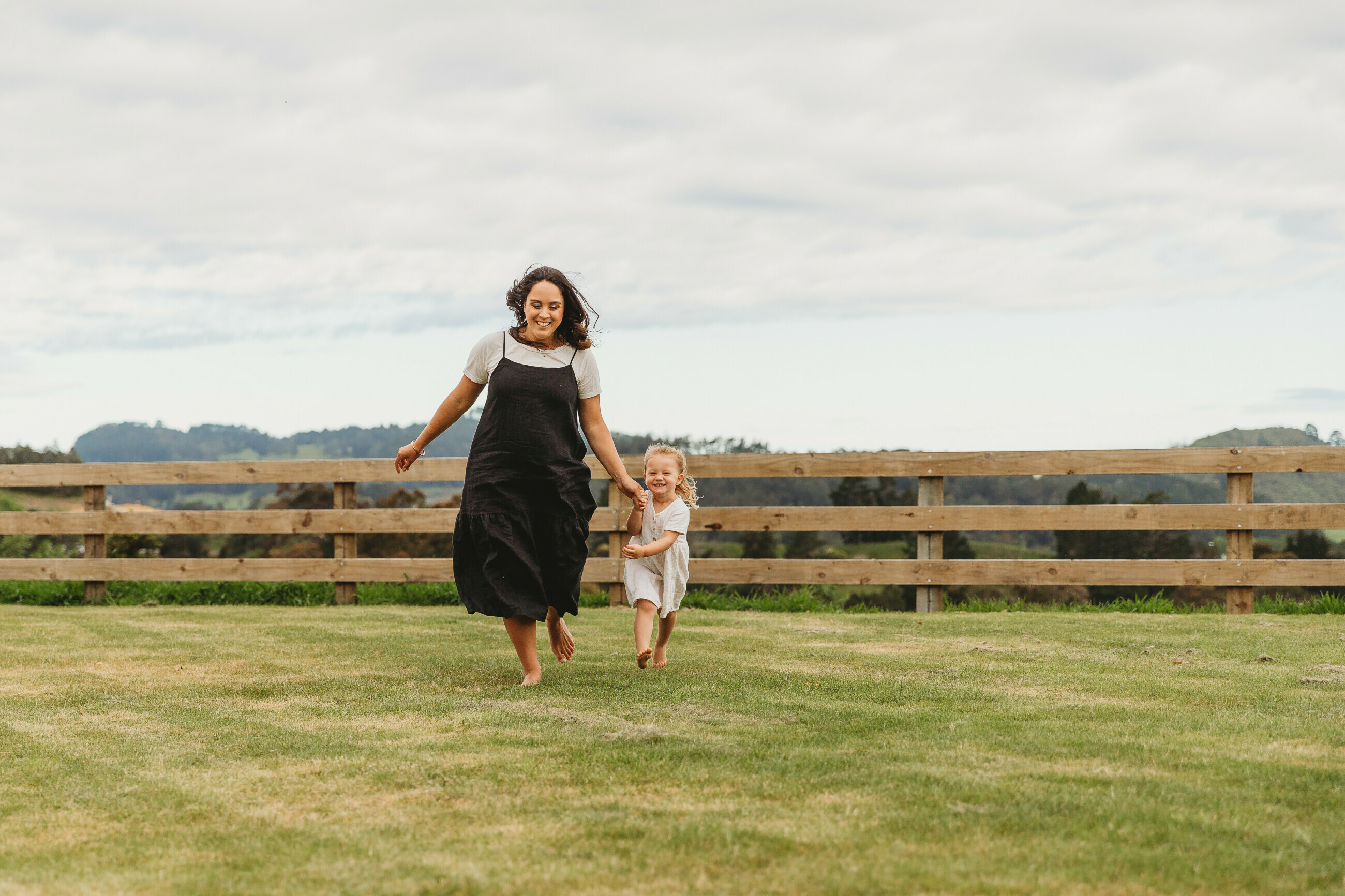 A woman running on grass with her daughter